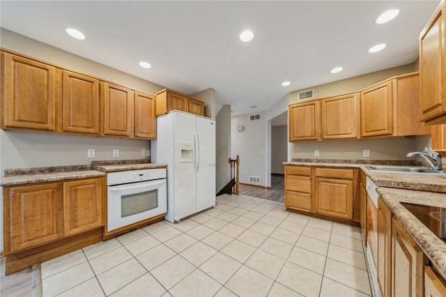 kitchen with white appliances, sink, and light tile patterned floors