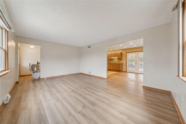 unfurnished living room featuring french doors and light hardwood / wood-style floors