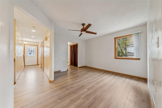 empty room featuring ceiling fan and light hardwood / wood-style flooring