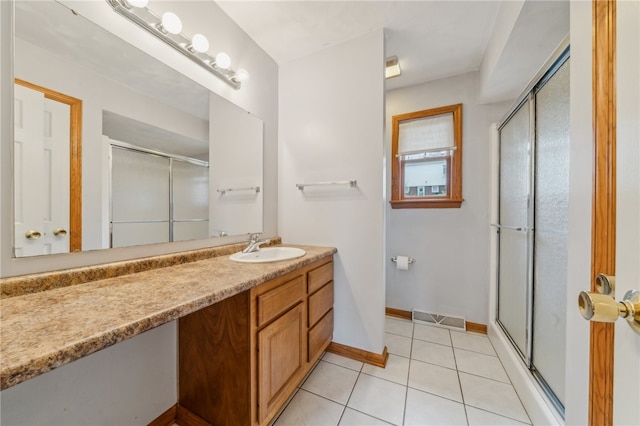 bathroom featuring an enclosed shower, vanity, and tile patterned floors