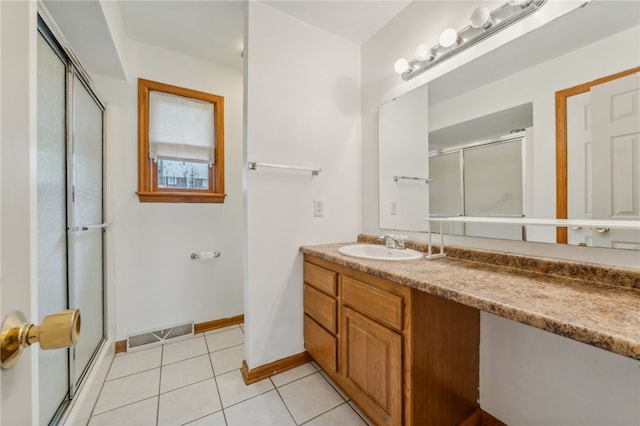 bathroom with tile patterned flooring, vanity, and a shower with shower door