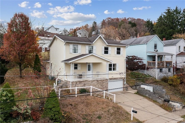 view of property with a porch and a garage