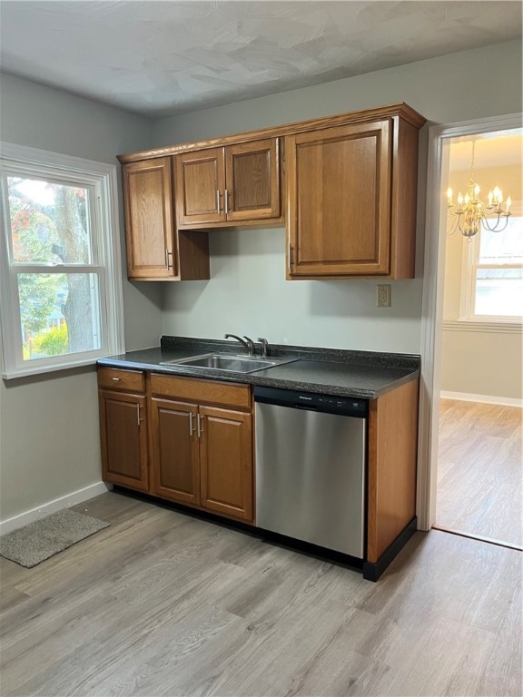 kitchen with stainless steel dishwasher, a wealth of natural light, sink, and light hardwood / wood-style flooring