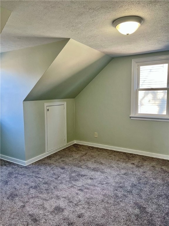 bonus room with carpet, a textured ceiling, and vaulted ceiling