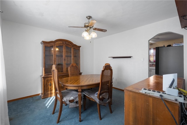 carpeted dining area with ceiling fan