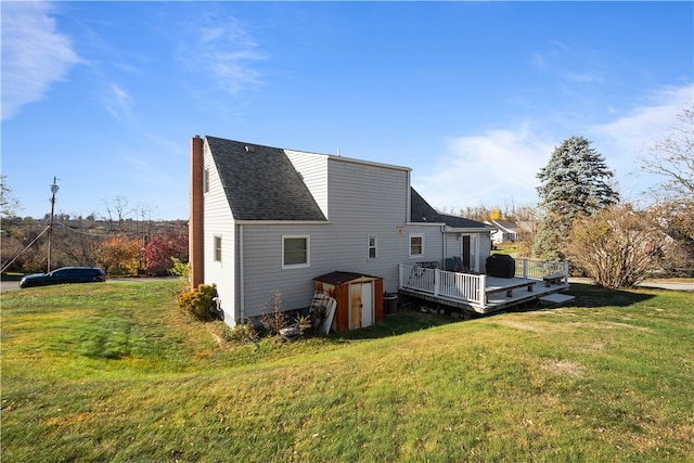 rear view of house featuring a wooden deck and a yard