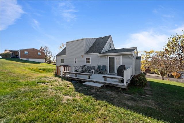 rear view of house featuring a deck and a lawn