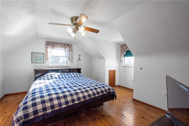 bedroom featuring light hardwood / wood-style flooring, lofted ceiling, and ceiling fan