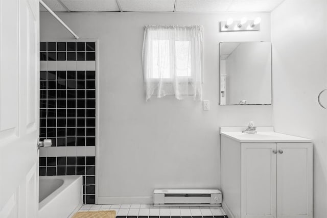 bathroom featuring vanity, shower / bath combination, tile patterned flooring, a baseboard heating unit, and a drop ceiling