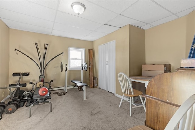 workout area featuring a paneled ceiling and light carpet