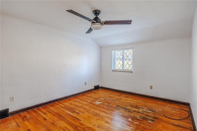 unfurnished room with hardwood / wood-style flooring, ceiling fan, and vaulted ceiling