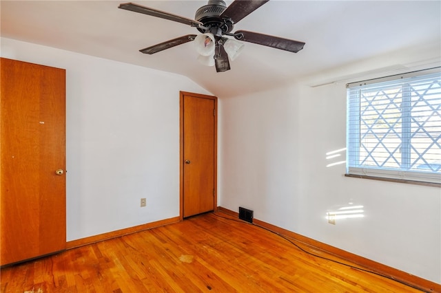 empty room featuring light hardwood / wood-style floors, ceiling fan, and vaulted ceiling