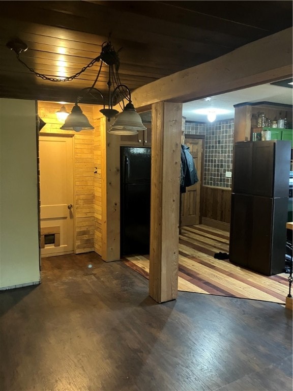 basement with black fridge, wooden walls, wood-type flooring, and wooden ceiling