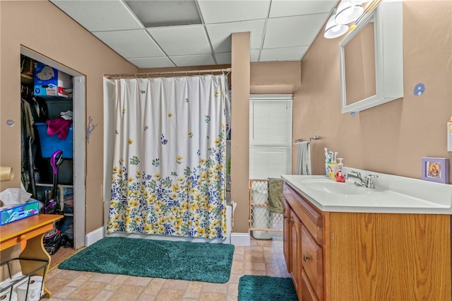 bathroom with a shower with shower curtain, vanity, and a paneled ceiling