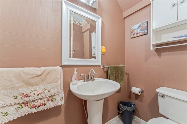 bathroom featuring toilet and tile walls