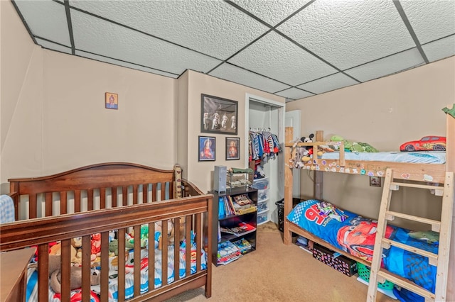 bedroom with a drop ceiling and carpet floors