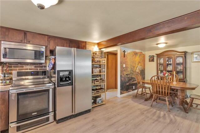 kitchen featuring appliances with stainless steel finishes, light hardwood / wood-style floors, and beam ceiling