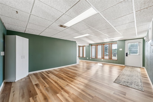 interior space featuring a paneled ceiling and hardwood / wood-style flooring