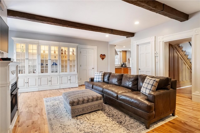 living room with beam ceiling and light hardwood / wood-style flooring