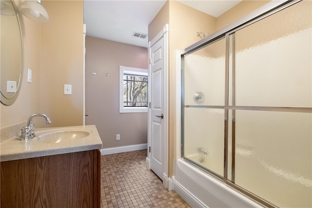 bathroom with combined bath / shower with glass door, vanity, and tile patterned flooring