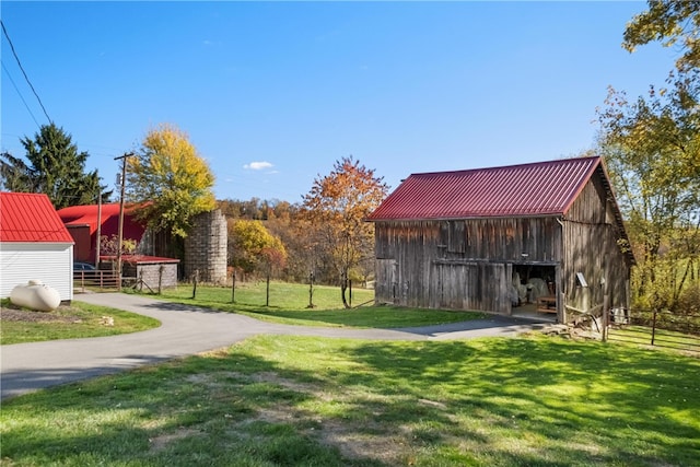 view of home's community with an outdoor structure and a yard