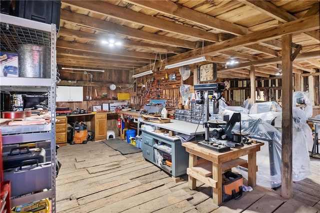 misc room with a workshop area, light hardwood / wood-style flooring, wood walls, and wood ceiling