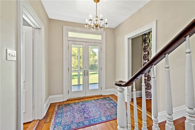 foyer entrance featuring an inviting chandelier, hardwood / wood-style flooring, and french doors