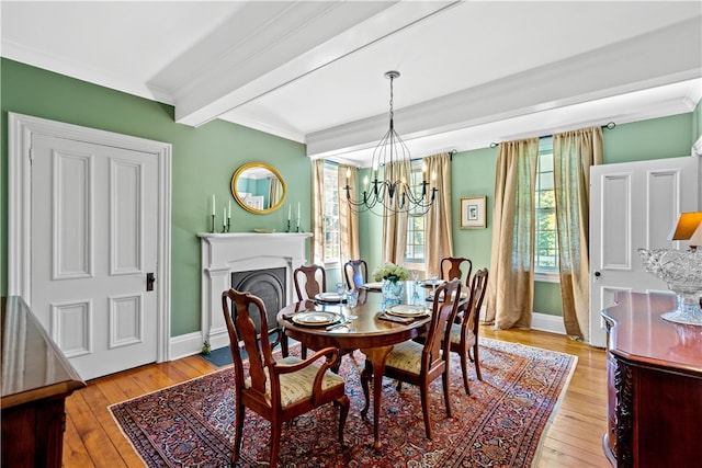 dining room with an inviting chandelier, beamed ceiling, light wood-type flooring, and crown molding