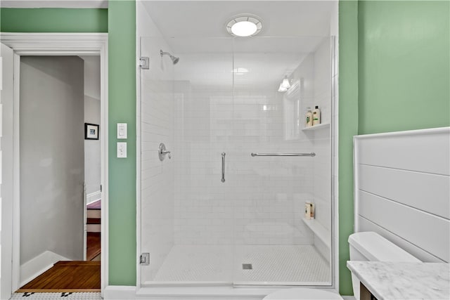 bathroom with toilet, an enclosed shower, and vanity