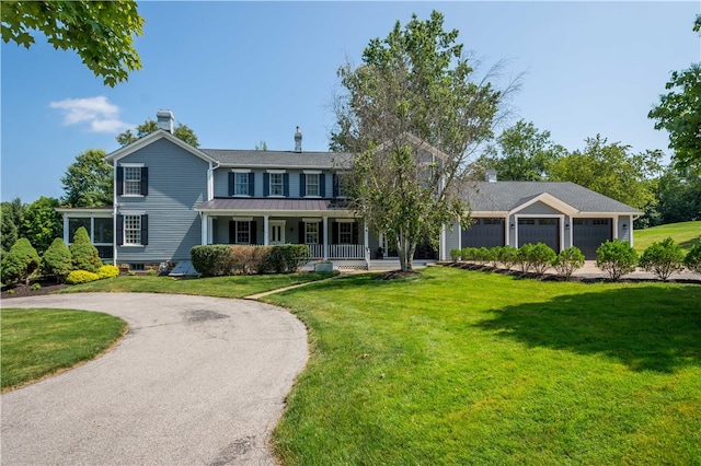 colonial home featuring a garage, a front yard, and a porch