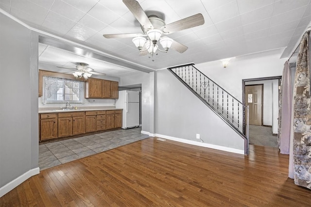 kitchen featuring light hardwood / wood-style floors, sink, ceiling fan, and white refrigerator