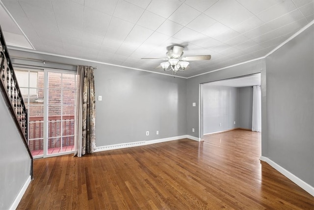 empty room featuring ceiling fan, hardwood / wood-style floors, and ornamental molding