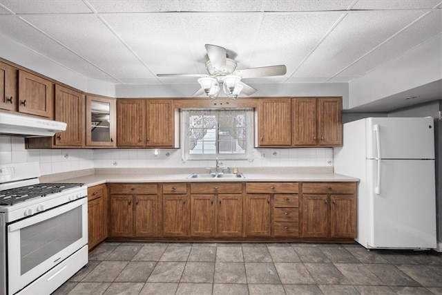 kitchen featuring tasteful backsplash, sink, white appliances, and ceiling fan