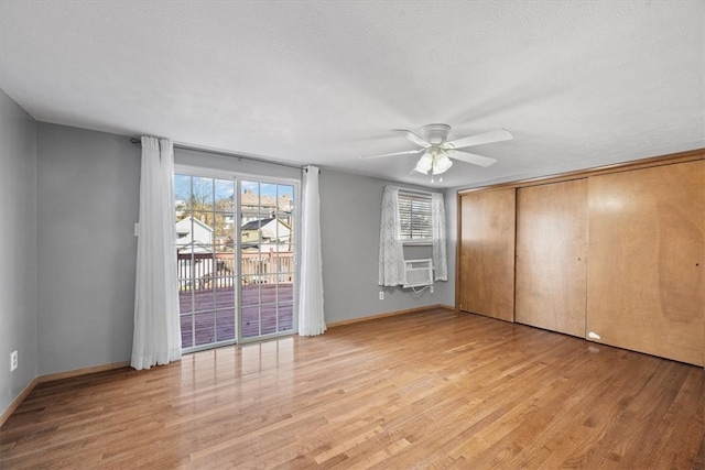 unfurnished bedroom with a closet, cooling unit, a textured ceiling, ceiling fan, and light hardwood / wood-style flooring