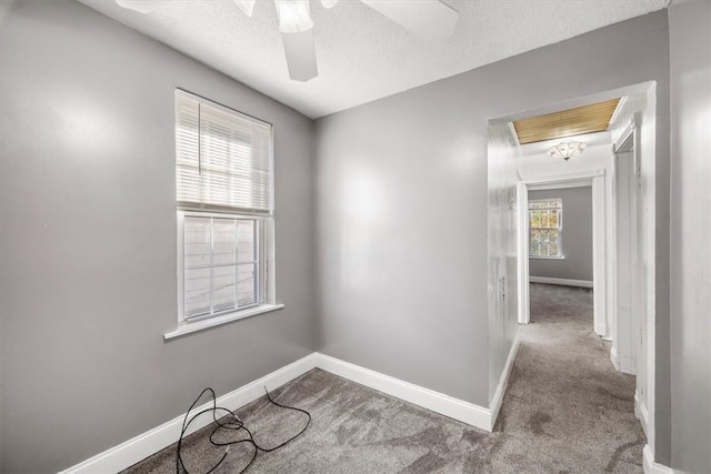 spare room with a textured ceiling, carpet flooring, and ceiling fan