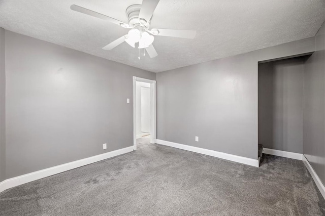 carpeted empty room with ceiling fan and a textured ceiling