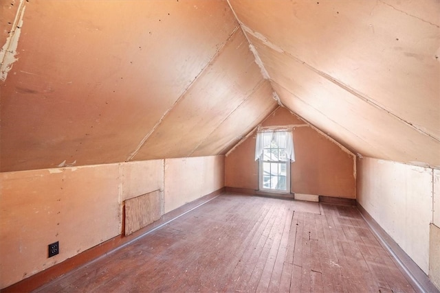 additional living space with light hardwood / wood-style floors and vaulted ceiling