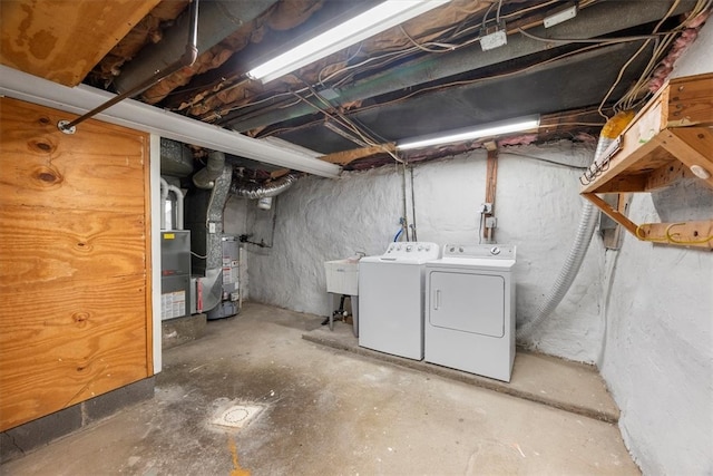 basement with water heater, sink, and washing machine and clothes dryer