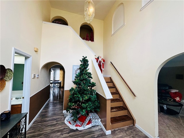 interior space with a high ceiling, a chandelier, and dark hardwood / wood-style floors