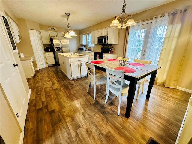 kitchen featuring a center island, white cabinetry, stainless steel appliances, and hanging light fixtures