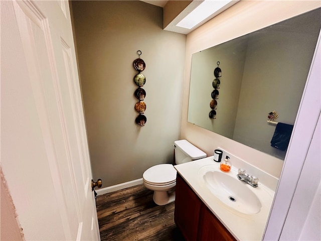 bathroom with hardwood / wood-style floors, vanity, and toilet