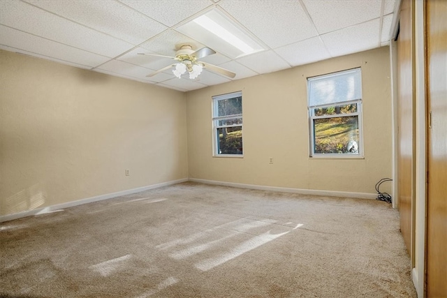 spare room featuring a paneled ceiling, light colored carpet, and ceiling fan