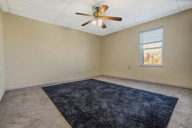 carpeted empty room with a paneled ceiling and ceiling fan