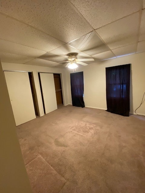 unfurnished bedroom featuring carpet flooring, a paneled ceiling, and ceiling fan