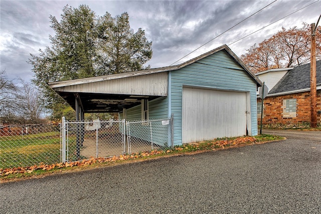 view of home's exterior with a garage, an outdoor structure, and a carport