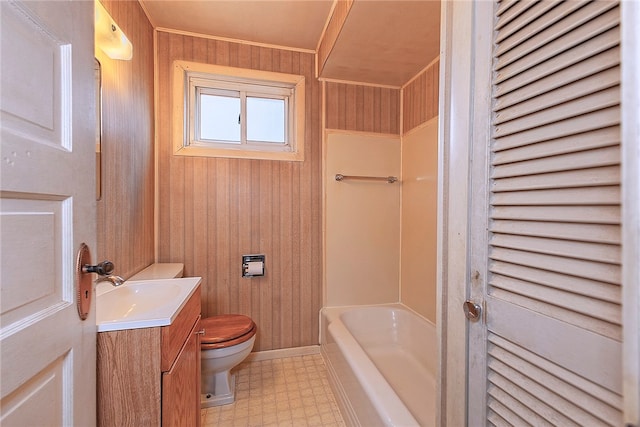 bathroom featuring vanity, a tub to relax in, and toilet