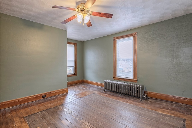 unfurnished room featuring ceiling fan, radiator, and wood-type flooring