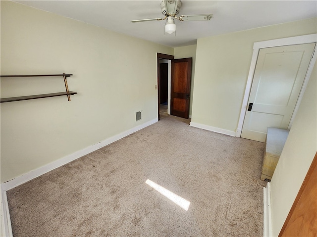 unfurnished bedroom with light colored carpet, ceiling fan, and a closet