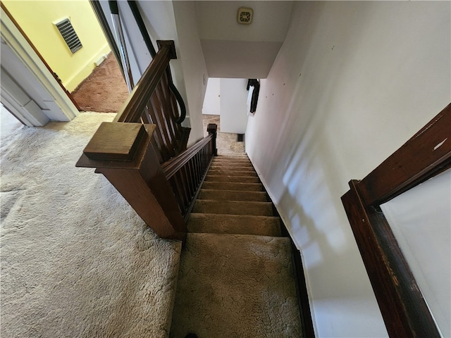 stairway featuring a towering ceiling and carpet floors