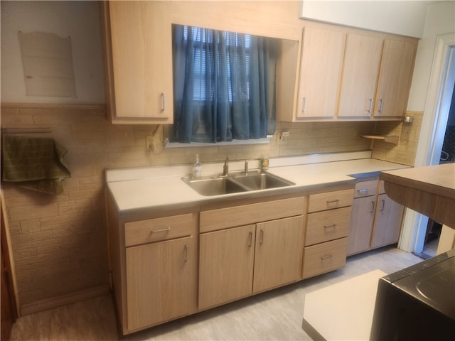 kitchen with light brown cabinets, light hardwood / wood-style floors, sink, and backsplash